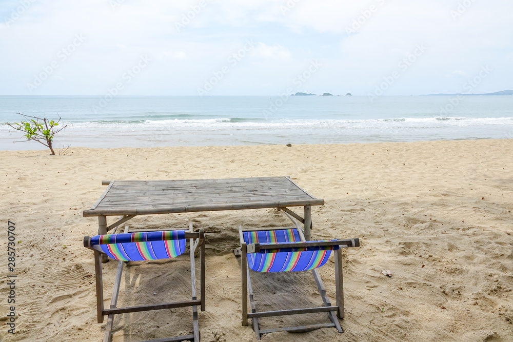 Beach chair on white sand with sea wave and sunny. Relaxing on the beach.