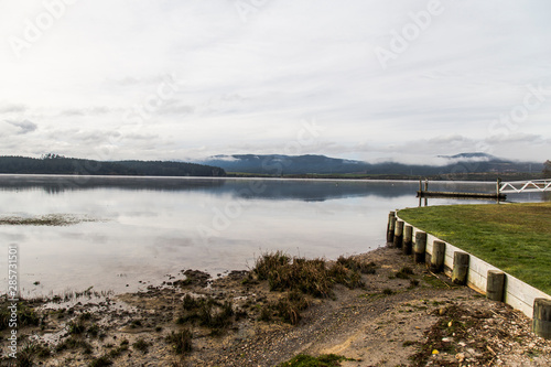 Lake Maraetai in Mangakino, Waikato district, New Zealand. Still waters, small boat jetty, reflections of cloud and sky. Moody, peaceful, reflective. Hydroelectric station, recreational activities. photo