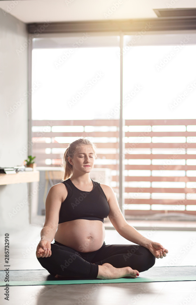 Living in harmony. Young pregnant woman doing yoga. Copy space in upper part
