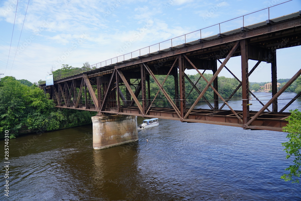 Train bridge connecting to plots of land over a beautiful river