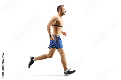 Fit guy jogging and wearing a chest strap monitor