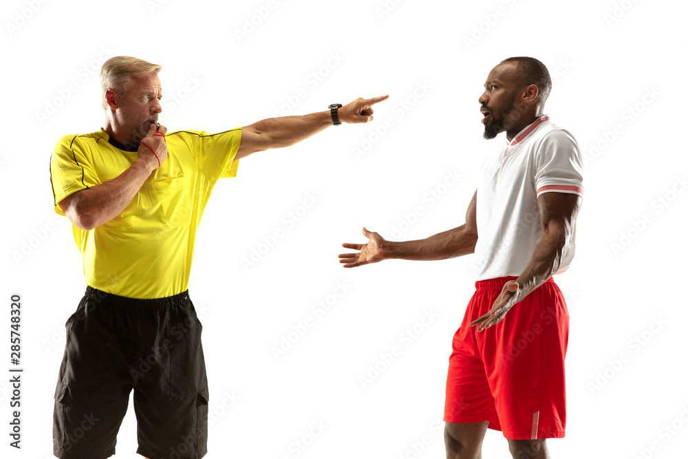 Referee gives directions with gestures to football or soccer players while gaming isolated on white studio background. Concept of sport, rules violation, controversial issues, obstacles overcoming. Referee gives directions with gestures to football or soccer players while gaming isolated on white studio background. Concept of sport, rules violation, controversial issues, obstacles overcoming.