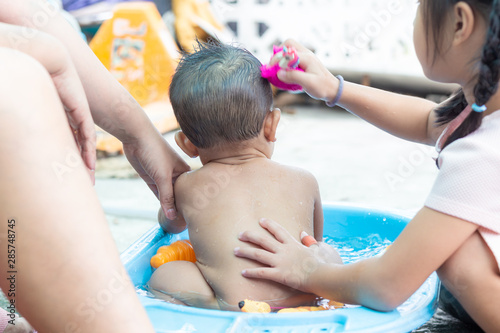 Toddler infant baby boy shoer in outdoor basin photo