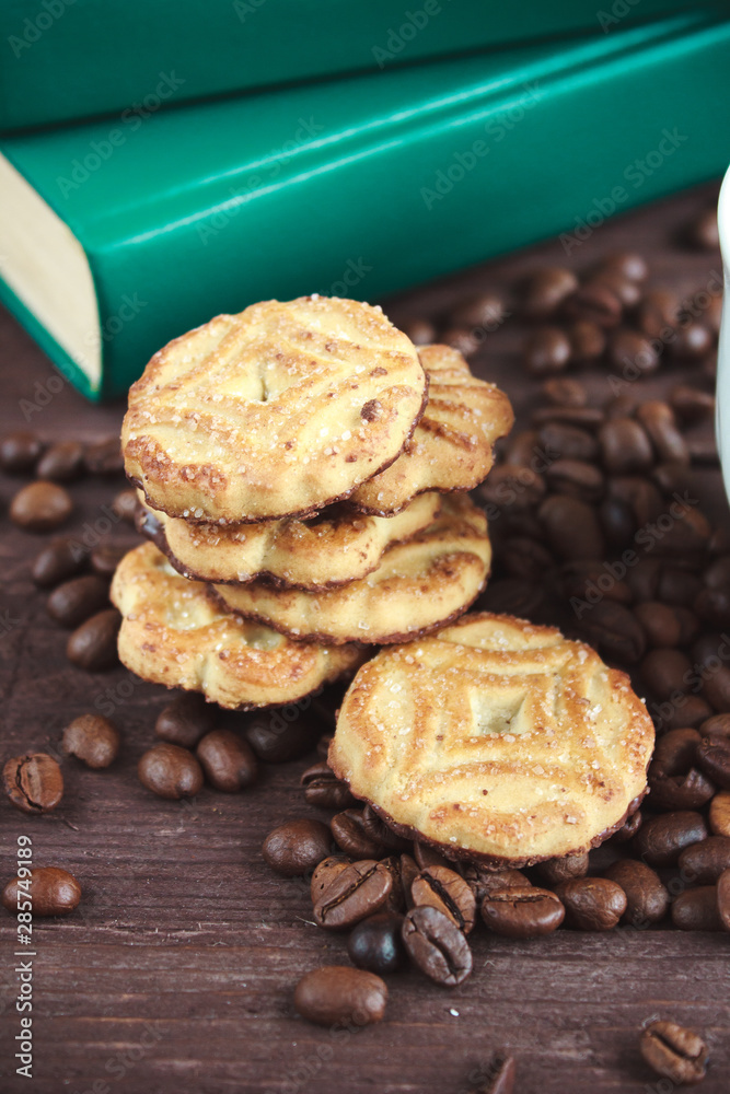 Coffee beans, cookies and book on a dark wooden table Coffee beans, cookies and book on a dark wooden table