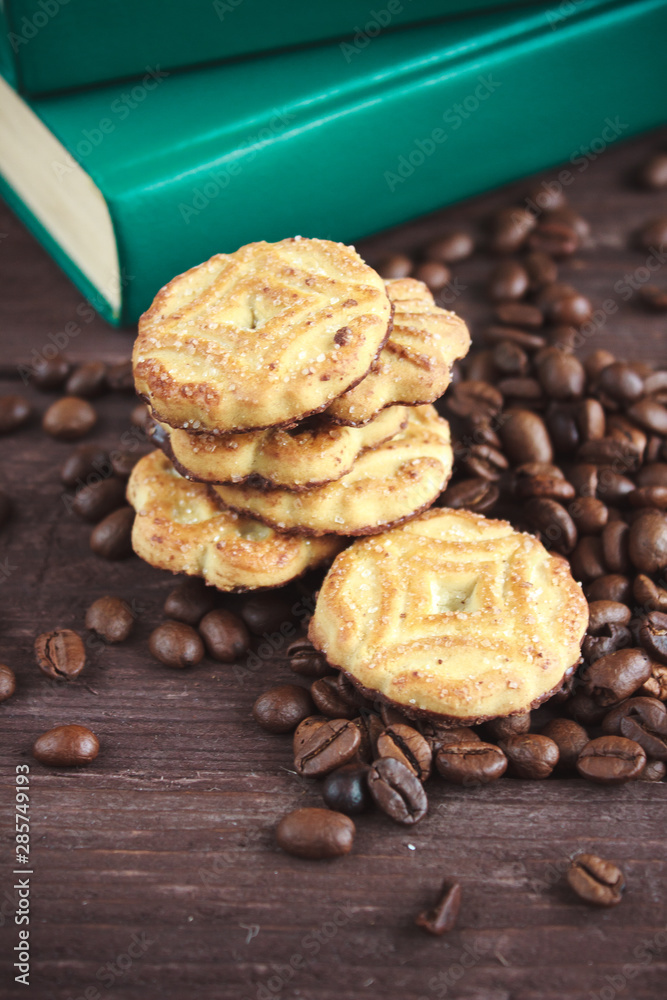 Fototapeta premium Coffee beans, cookies and book on a dark wooden table