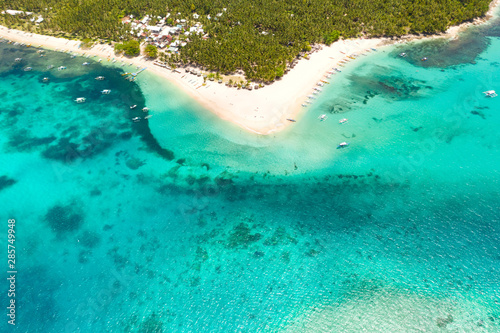 Beautiful tropical island in sunny weather, view from above. Daco island, Philippines. White sandy beach and turquoise lagoon.