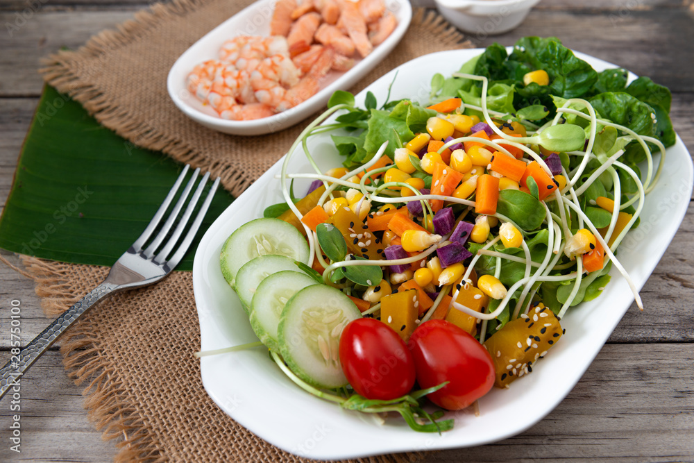 Fresh salad plate with shrimp, salmon, tomato and mixed greens on wooden background . Fresh salad plate with shrimp, salmon, tomato and mixed greens on wooden background .