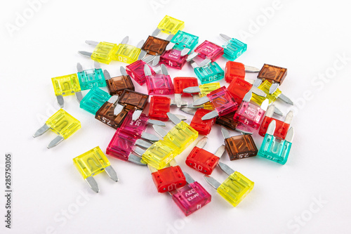 Mini blade fuses with different ampers on isolated white backgrounds. Electric car parts.