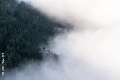 view of flying clouds over valley in mountains