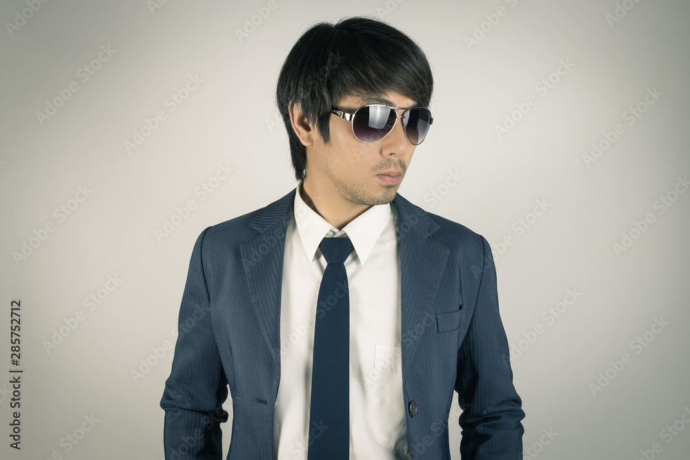 Young Asian Portrait Businessman Wear Sunglasses and Look Beside in Vintage Tone Young Asian Portrait Businessman Wear Sunglasses and Look Beside in Vintage Tone