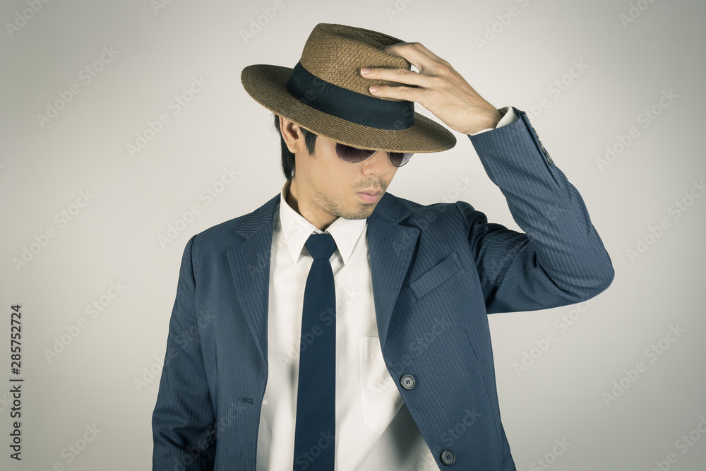 Young Asian Portrait Businessman Wear Sunglasses and Touch Top of Hat in Vintage Tone Young Asian Portrait Businessman Wear Sunglasses and Touch Top of Hat in Vintage Tone