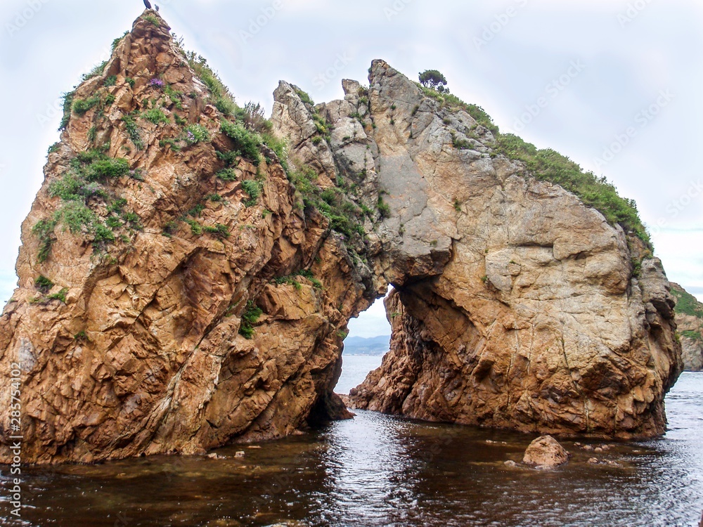 Rocky arc in the water of Japanese sea near Vrangel, Primorsky Krai, Russia.