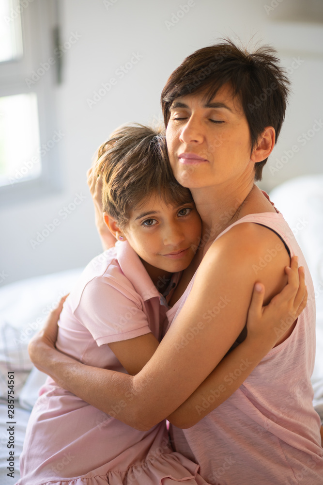 Beautiful young woman and her charming little daughter are hugging. Beautiful young woman and her charming little daughter are hugging.
