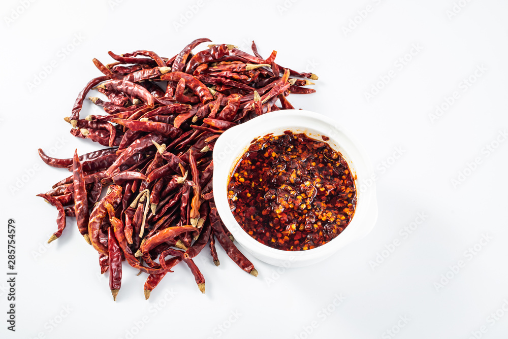 Fototapeta premium Ceramic stew with red pepper and dried chili on white background