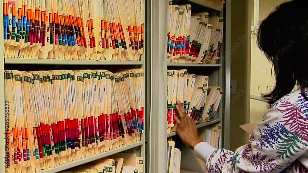 A medical worker files a patient's chart.