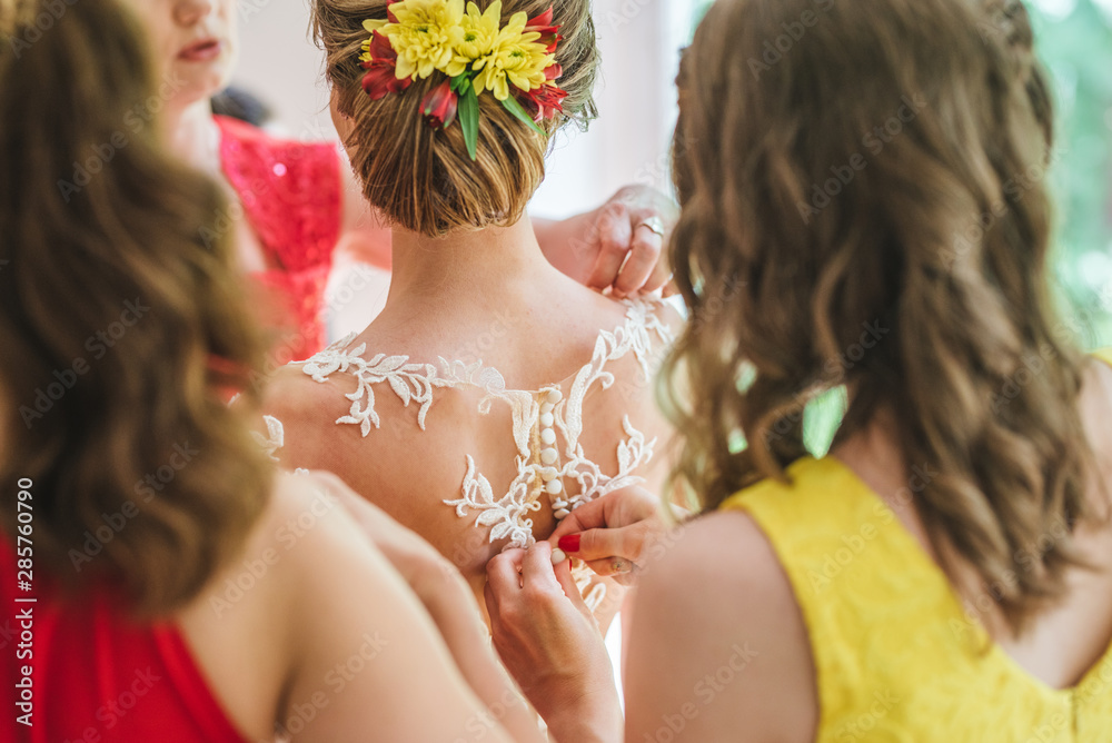 Naklejka premium Bride getting ready by a bridesmaid