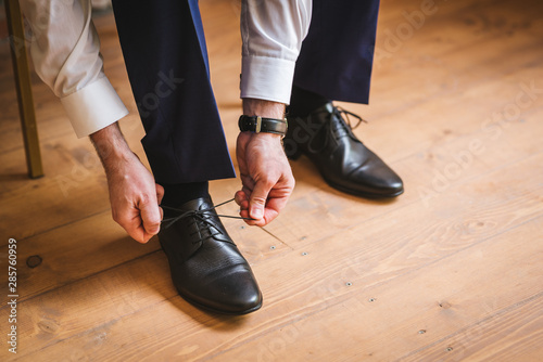 Groom Tying His Shoes on the wedding day. Black and white image