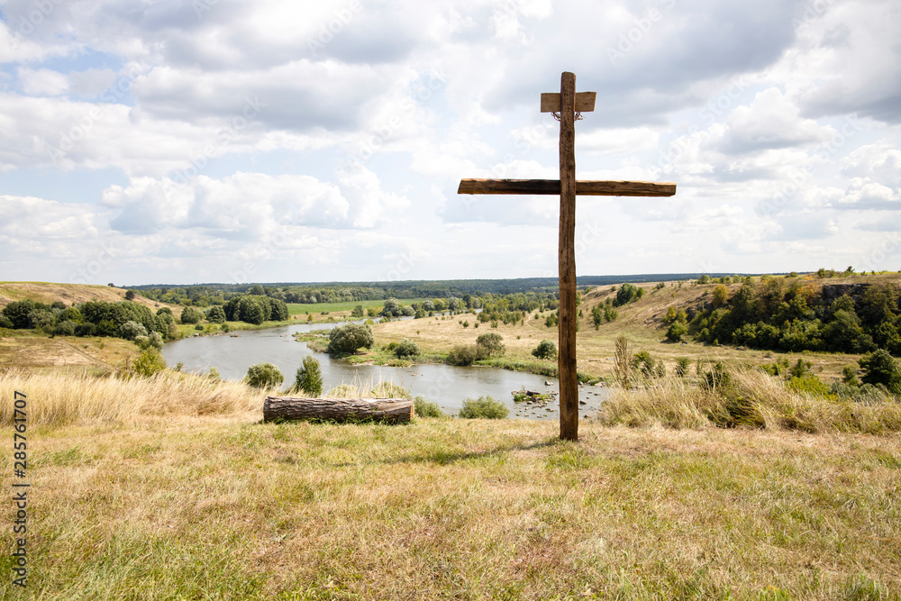 Wood cross on blue sky. The Cross with bright sun and clouds in the background. Christian background. Wood cross on blue sky. The Cross with bright sun and clouds in the background. Christian background.