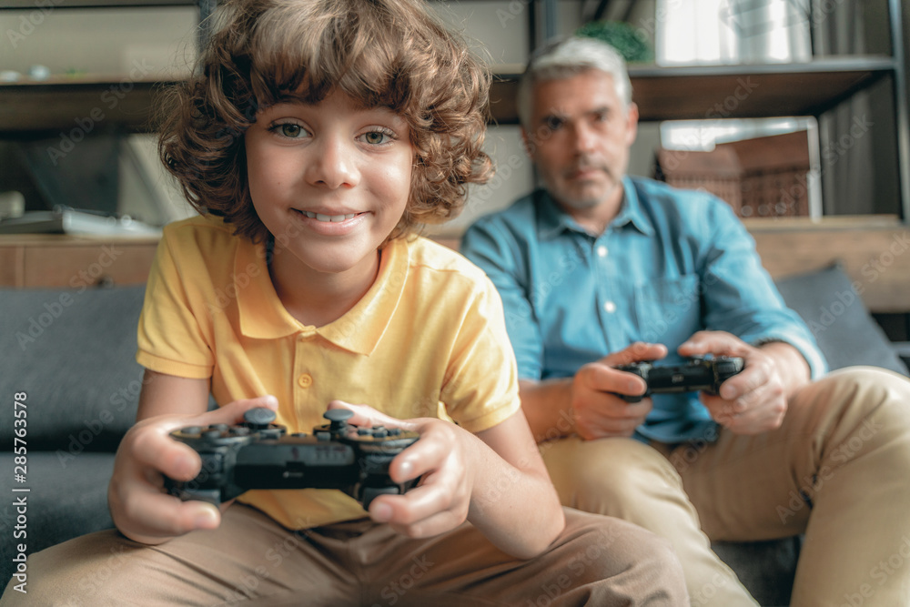 Mature father with son playing in video games Mature father with son playing in video games
