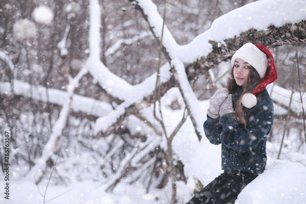Girl in a winter park in snowfall Girl in a winter park in snowfall
