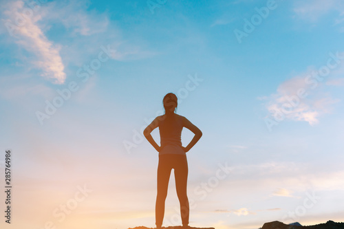 silhouette woman standing and relaxing on top of mountain