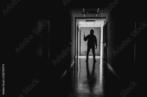 murder  kill and people concept - Criminal or murderer wearing a mask in silhouette holding knife inside a condo at crime scene