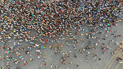 Aerial. People crowd on a city square. Mass gathering of many people in one place. Top view from drone fly.