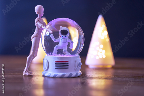 A spaceman meets an alien in a snowball.