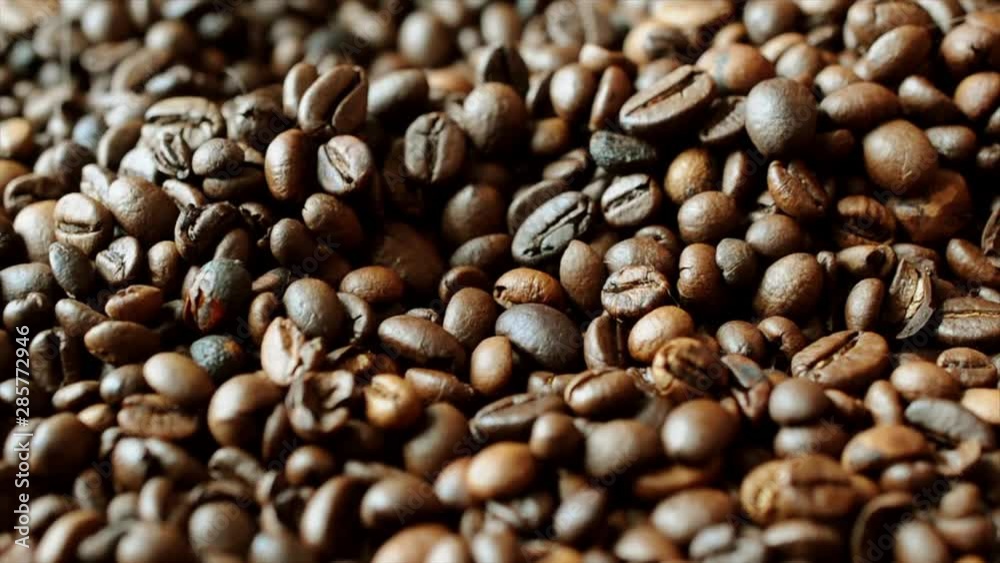 Man hand caressing fresh roasted coffee beans in morning light Man hand caressing fresh roasted coffee beans in morning light