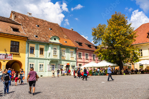 Sighisoara, Romania - 2019. People wandering on the streets of Sighisoara citadel (old town). Streets with colorful houses.