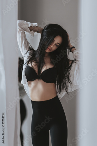 Stock Image Details: ING_19070_01427 - indoor glamour portrait of seductive  young female in erotic pose wearing only white panties and sensual open  shirt, looking in camera with charming expression