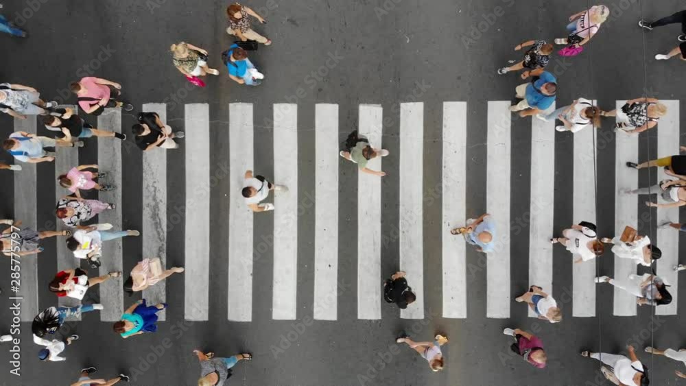 Aerial. People crowd on pedestrian crosswalk. Top view background.