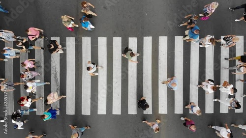 Aerial. People crowd on pedestrian crosswalk. Top view background.