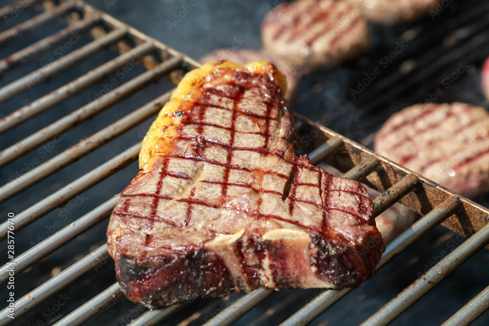 A top sirloin steak flame broiled on a barbecue, shallow depth of field.