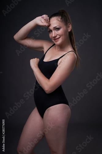 flexible sexy girl poses on a black grey background in the fitting clothes baud © nikolay_alekhin