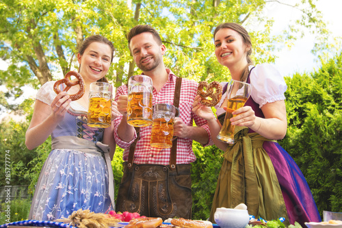 Young people in Tracht, Dindl and Lederhosen having fun in Beer garden photo