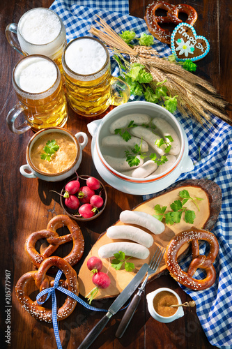 Bavarian sausages with pretzels, sweet mustard and beer mugs photo