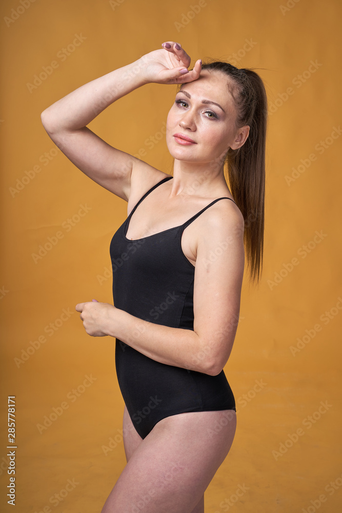 flexible sexy girl posing on a yellow background in tight-fitting clothes bodysuit flexible sexy girl posing on a yellow background in tight-fitting clothes bodysuit
