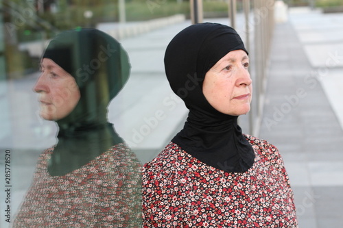 Serious Arabic woman with her own reflection