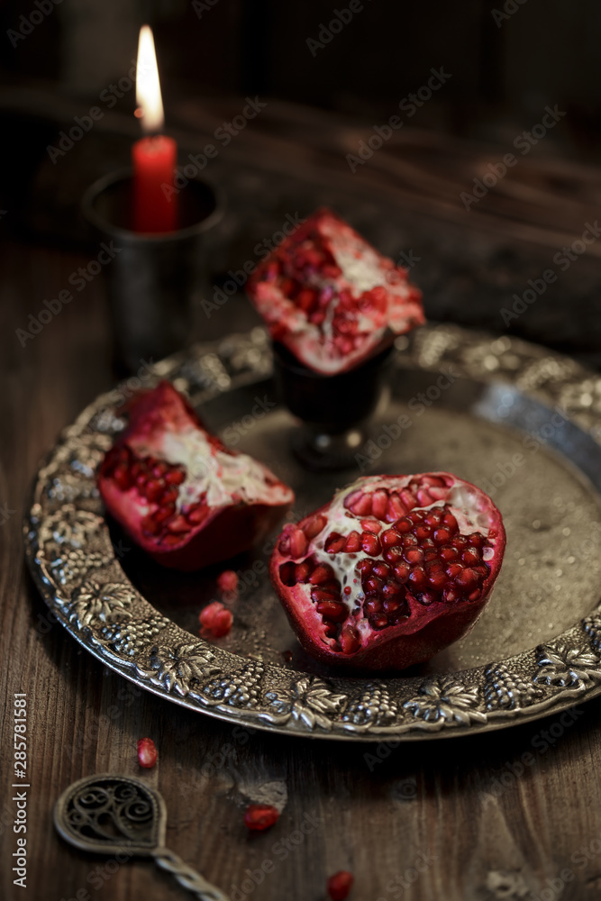 Pomegranate peeled on a silver plate, on a dark wooden table. Pomegranate peeled on a silver plate, on a dark wooden table.