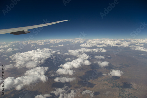 Airplane Wing and Clouds Viewed from Inside the Aircraft. Travel concept with copy space.