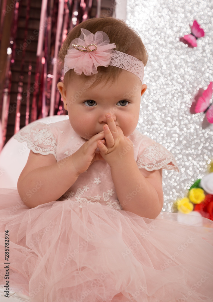 beautiful fashionable little baby in pink dress. little princess poses like a doll beautiful fashionable little baby in pink dress. little princess poses like a doll
