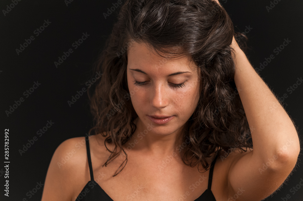 Young brunette girl photographed in studio with black background Young brunette girl photographed in studio with black background