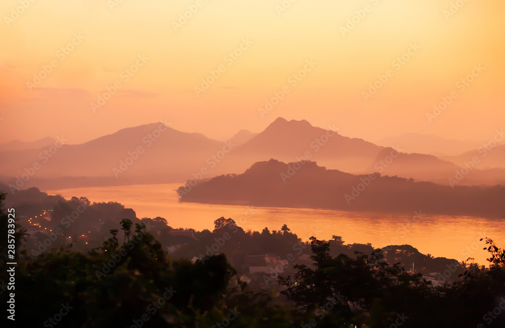 Picturesque Mekong River and Luang Prabang town at dusk.