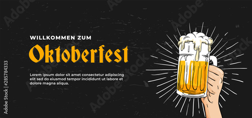 Willkommen Zum Oktoberfest poster banner template design. hand holding full glass of bear vector illustration on scratched black board background. German translation : Welcome to