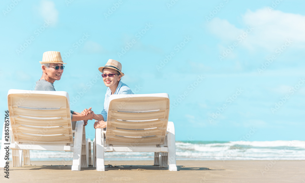 Senior caucasian couple sitting on bench near the sea and hugging. Horizontal shape, rear view, copy space