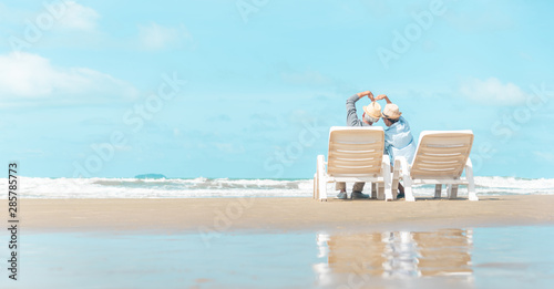 Happy old people asian relaxing on beach at morning back view