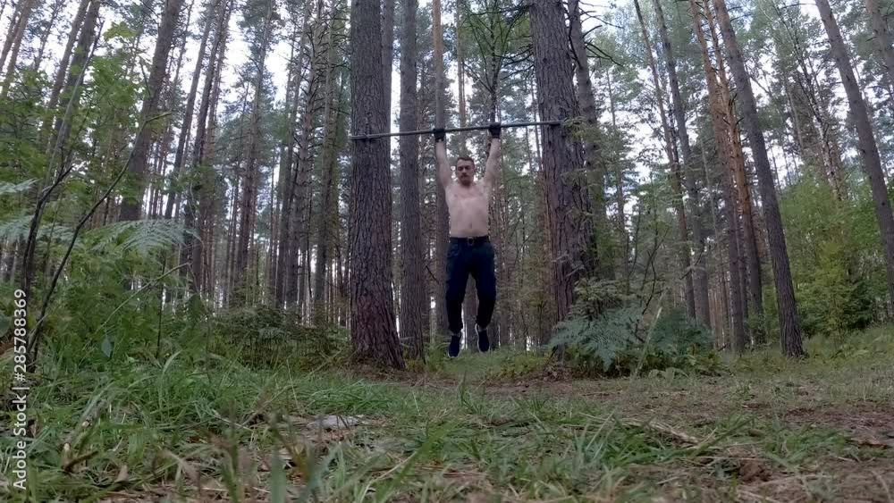 Man working out in forest calisthenics style Man working out in forest calisthenics style