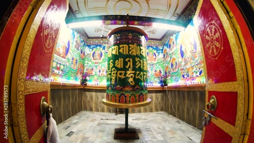 Beautiful huge bhuddhist prayer wheel in an ornately decorated room shot with a fisheye lens photo