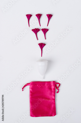 Fototapeta Naklejka Na Ścianę i Meble -  Close up of woman hand holding white menstrual cup sanitary napkin tampon on pink background health qynecology concept 